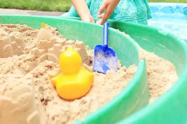 child playing on circular sandbox