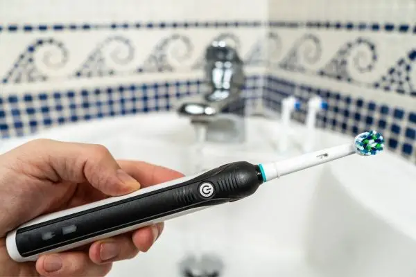 man holding an electric toothbrush