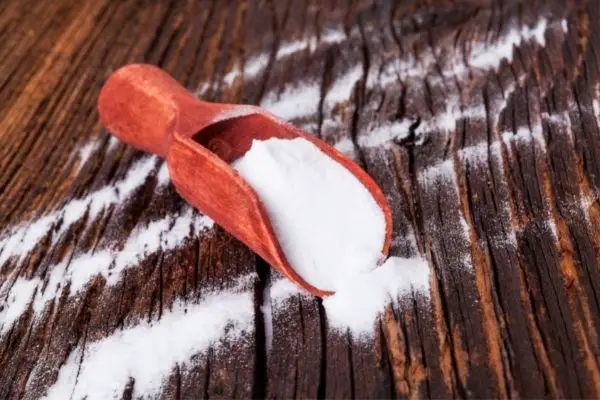 big scoop of baking soda on wooden floor