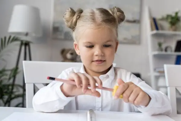 young girl shaving pencil