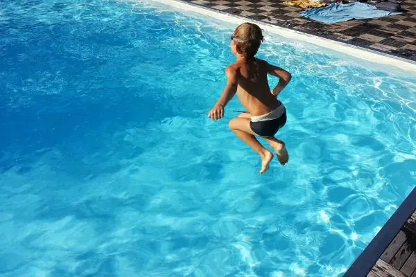 boy jumping in the pool