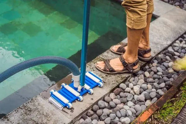 man setting up a pool vacuum