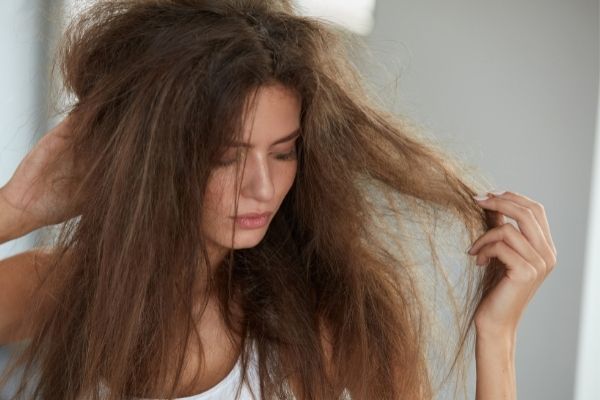 Woman Stressed Out From Thinking How To Get Sand Out Of Hair