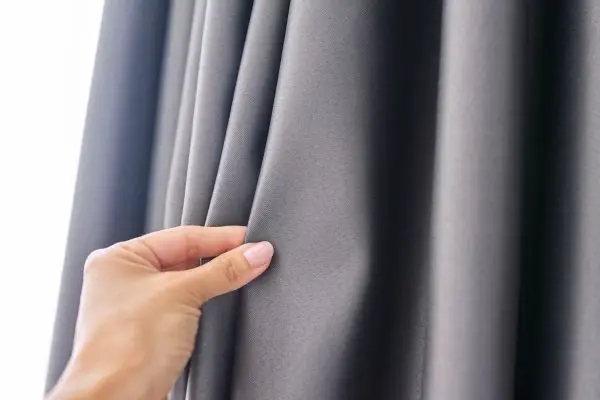 Person Holding Thick Black Curtains