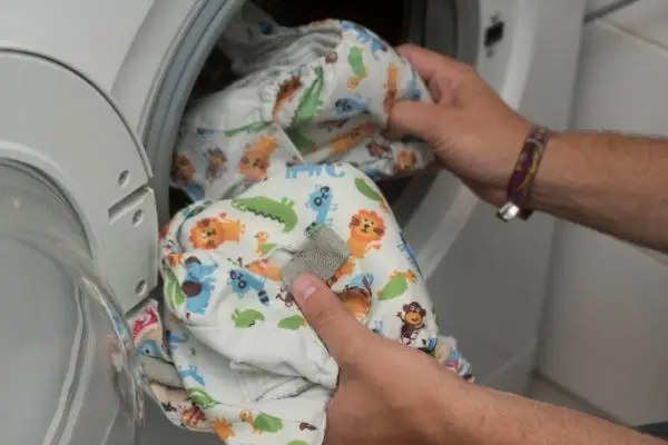Person Washing Cloth Diapers In Washing Machine