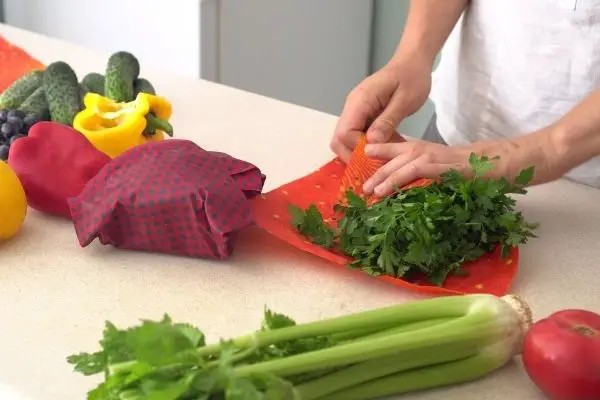 Person Wrapping Vegetables In Beeswax Wraps