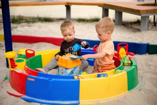 Young Boys Playing In Colorful Plastic Sandbox