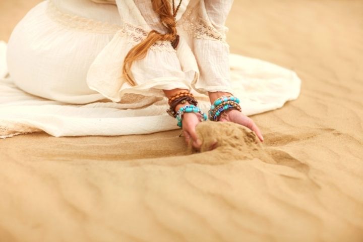 A Girl Is Holding Sand When Sits On It