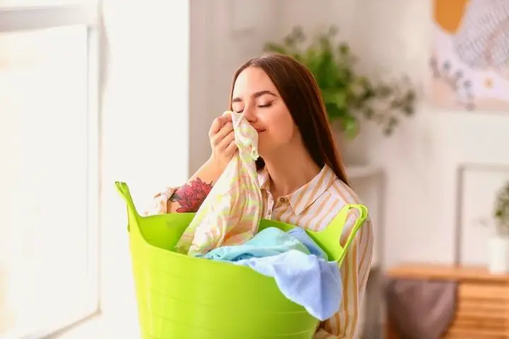A Woman Sniffs Clothes After Laundry