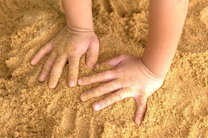 Kid Put Hands On The Sand