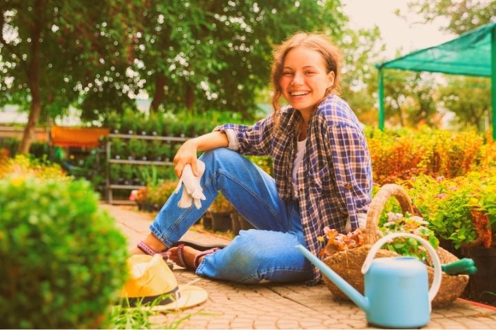 Woman Gardener Is Sitting On A Ground
