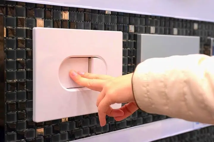 Woman Is Pushing A Toilet Button