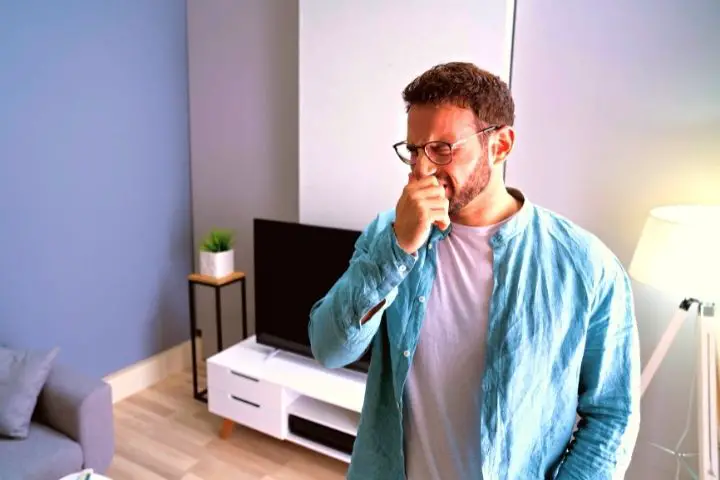 A Man Covers His Nose From A Bad Smell