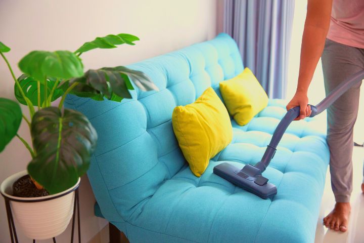 A Woman Is Vacuuming Couch
