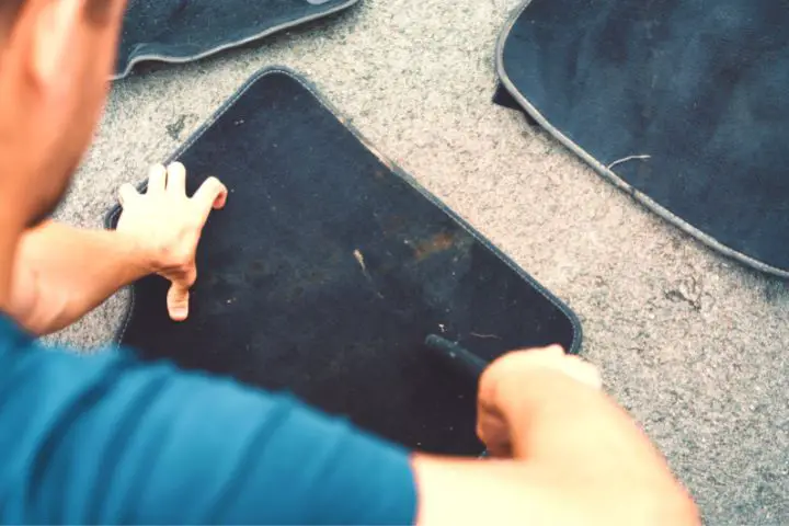 Man Is Cleaning Cloth Car Mats