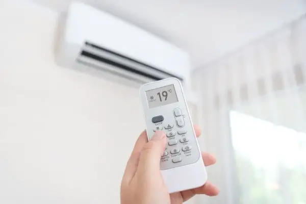 Person Turning On Air Conditioner At Home