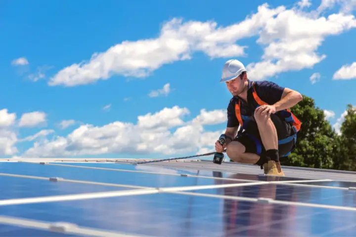 Solar Panel Technician With Drill Installing Solar Panels