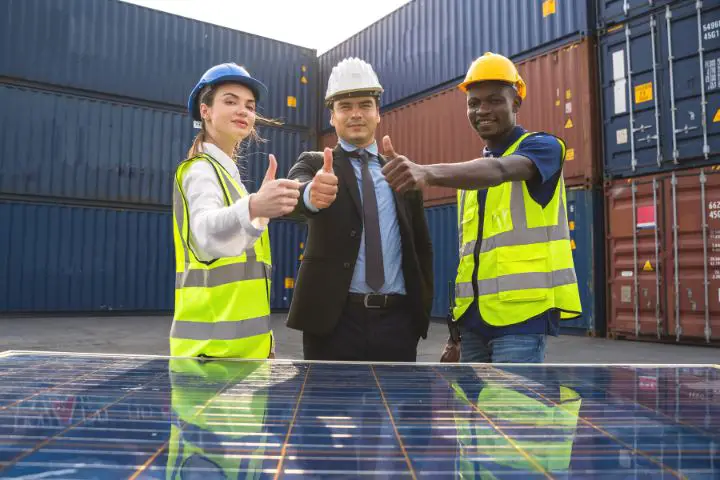 Engineer And Technician Team With Thumbs Up Next To Solar Panel